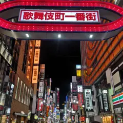 Entrada al barrio rojo de Tokio, con un letrero brillante y luces rojas.