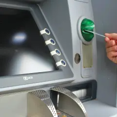 Mano insertando una tarjeta N26 extranjero en un cajero automático.