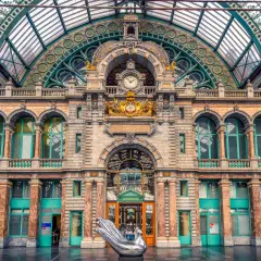 La estación de tren Bruselas Amberes, con su impresionante arquitectura y un ave plateada, te da la bienvenida.