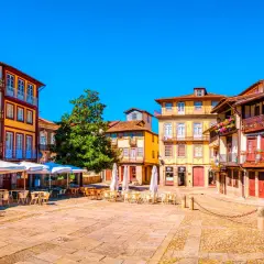 Plaza con edificios coloridos y terrazas. Un lugar perfecto donde viajar en marzo Europa para disfrutar del sol y la arquitectura.