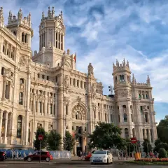 Edificio de Correos y Telégrafos, un lugar clave que ver en Madrid en un día. Fachada monumental, torre con reloj y cielo azul.