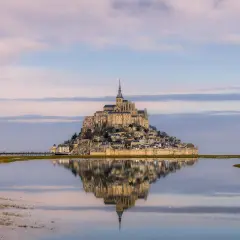 Mont Saint-Michel como llegar: la abadía reflejada en el agua, un sueño al amanecer.