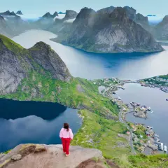 Una persona contempla las majestuosas islas Lofoten. Descubre cómo llegar a este paraíso noruego.