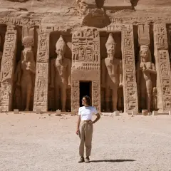 Mujer posa frente a colosales estatuas en Abu Simbel. ¡Excelentes consejos para viajar a Egipto!