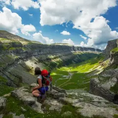 Senderista admira el valle verde de Ordesa y Monte Perdido. Un paisaje espectacular para descubrir qué ver en Ordesa y Monte Perdido.
