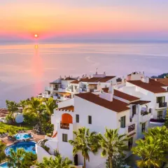 Resort con piscinas y palmeras al atardecer. Un lugar ideal para tus destinos para viajar en enero.