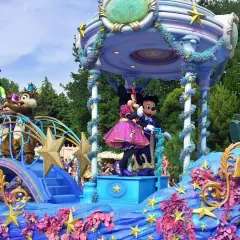 Mickey y Minnie bailan en una carroza mágica en Disneyland Paris, rodeados de Chip y Dale, y otros personajes.