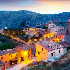 Pueblo medieval iluminado al atardecer, ideal para descubrir sitios para visitar en España un fin de semana.