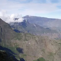 Impresionantes montañas en la isla Reunión, con nubes que envuelven picos escarpados, sugiriendo los peligros de su terreno.