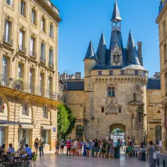 Plaza con la Giralda de Burdeos y edificios históricos. Gente paseando y disfrutando de terrazas. Merece la pena visitar Burdeos.