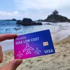 Tarjeta Revolut "Guía Low Cost" en una playa paradisíaca. Descubre cómo funciona Revolut en el extranjero sin comisiones ocultas.