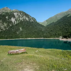 Paisaje sereno de los lagos de Ayous, con montañas cubiertas de pinos y un lago turquesa.