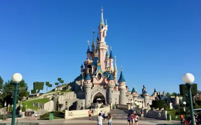 El castillo de la Bella Durmiente se alza majestuoso bajo un cielo azul, invitando a la fantasía.