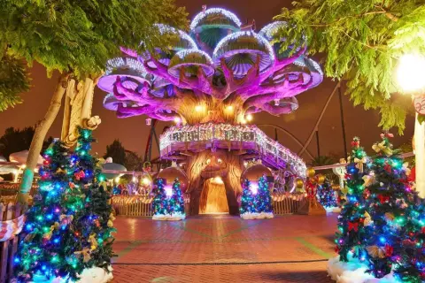 Árboles de Navidad iluminados y decorados en PortAventura en Navidad, con un árbol central gigante y luces festivas.