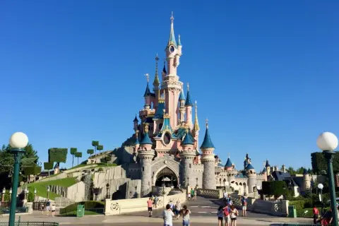 El castillo de la Bella Durmiente se alza majestuoso bajo un cielo azul, invitando a la fantasía.