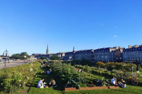 Gente relajándose en un jardín urbano con vistas a Burdeos. ¡Así se llega a la tranquilidad!