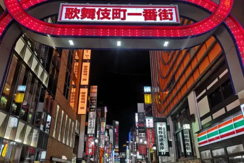 Entrada al barrio rojo de Tokio, con un letrero brillante y luces rojas.