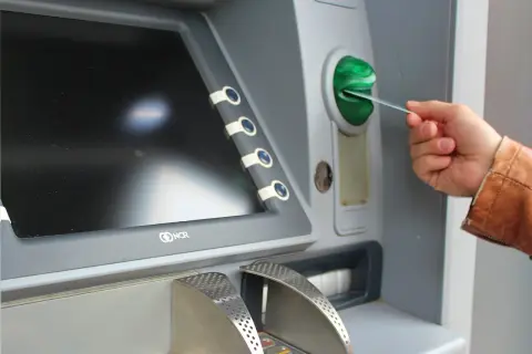 Mano insertando una tarjeta N26 extranjero en un cajero automático.