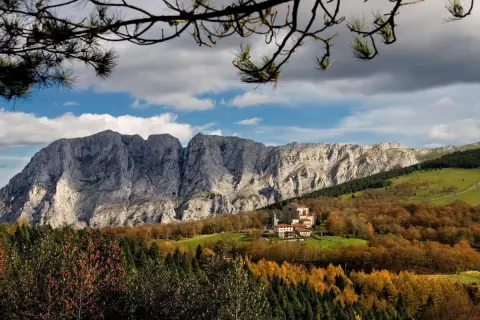 Impresionante paisaje otoñal en Álava, con un monasterio y montañas rocosas. ¡Mucho que ver en Álava!