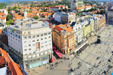 Vista aérea de la plaza principal de Zagreb, con edificios históricos, gente paseando y terrazas. Un lugar ideal para descubrir qué ver en Zagreb.