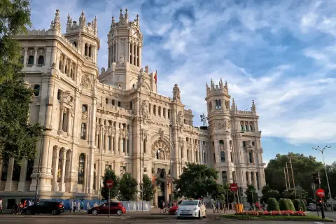 Edificio de Correos y Telégrafos, un lugar clave que ver en Madrid en un día. Fachada monumental, torre con reloj y cielo azul.