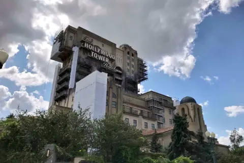 La imponente Hollywood Tower Hotel de Disneyland Paris, con andamios y cubiertas, se alza bajo un cielo nublado.