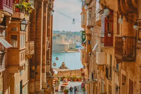 Calle estrecha con balcones de madera y vistas al mar. Ideal para escapadas fin de semana Europa.
