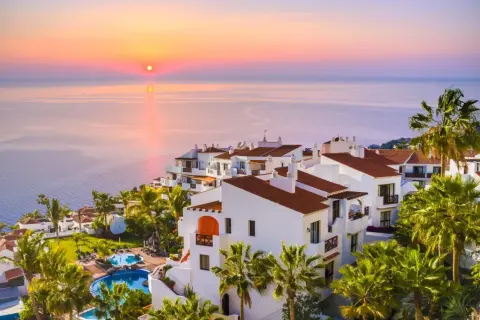 Resort con piscinas y palmeras al atardecer. Un lugar ideal para tus destinos para viajar en enero.