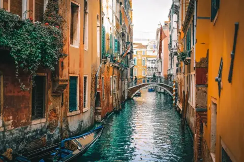 Un canal veneciano con góndola y un puente. El viaje de Milán a Venecia es un sueño hecho realidad.