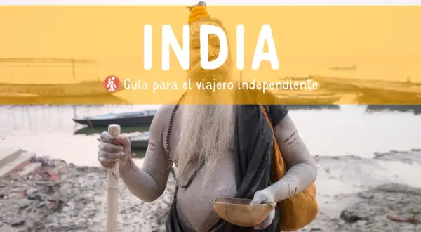 Un sadhu con barba y cuerpo cubierto de ceniza sostiene un bastón y un cuenco. Texto: "INDIA. Guía para el viajero independiente". Consejos para viajar a la India.