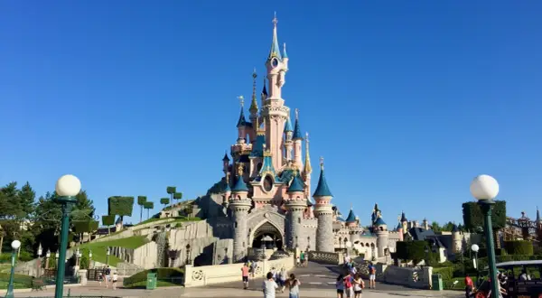 El castillo de la Bella Durmiente se alza majestuoso bajo un cielo azul, invitando a la fantasía.