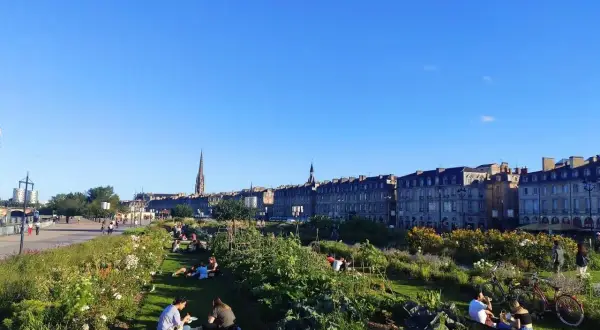 Gente relajándose en un jardín urbano con vistas a Burdeos. ¡Así se llega a la tranquilidad!