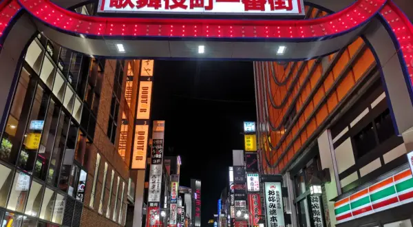 Entrada al barrio rojo de Tokio, con un letrero brillante y luces rojas.