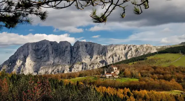 Impresionante paisaje otoñal en Álava, con un monasterio y montañas rocosas. ¡Mucho que ver en Álava!