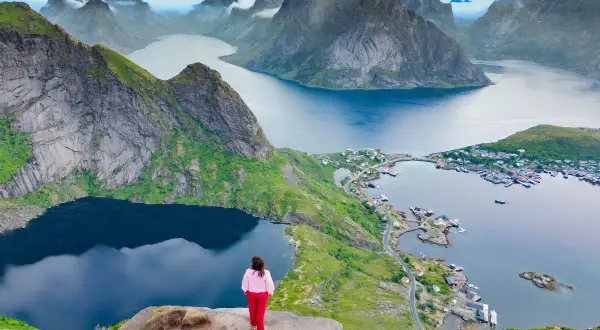 Una persona contempla las majestuosas islas Lofoten. Descubre cómo llegar a este paraíso noruego.