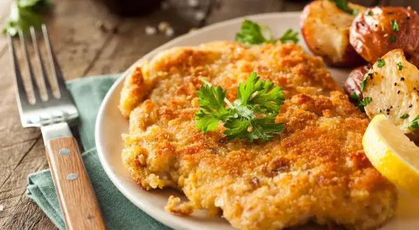 Wiener Schnitzel dorado, patatas asadas y limón. ¡Una excelente opción para saber qué comer en Viena!