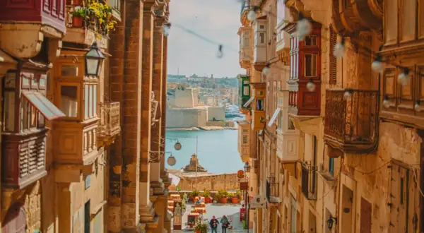 Calle estrecha con balcones de madera y vistas al mar. Ideal para escapadas fin de semana Europa.
