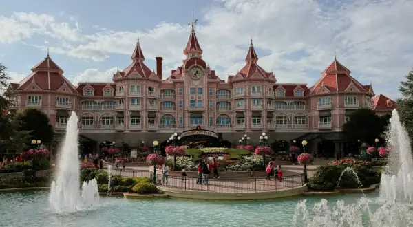 El hotel rosa de Disneyland Paris con fuentes y flores. ¡Un lugar mágico para hacer camping y disfrutar!