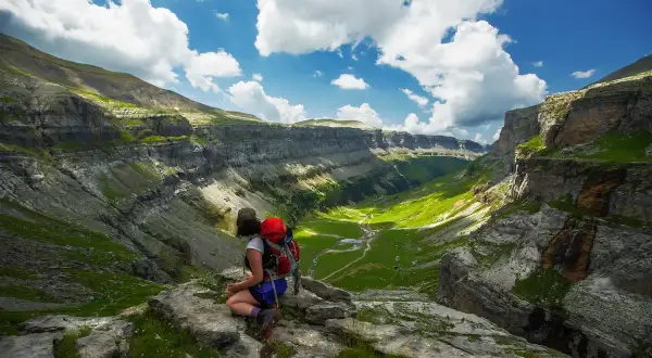 Senderista admira el valle verde de Ordesa y Monte Perdido. Un paisaje espectacular para descubrir qué ver en Ordesa y Monte Perdido.