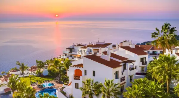Resort con piscinas y palmeras al atardecer. Un lugar ideal para tus destinos para viajar en enero.