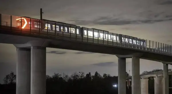 Un tren ilumina la noche sobre un viaducto, parte de las **líneas metro París**. Sus luces brillan a través de las ventanas, creando un espectáculo nocturno.