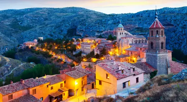 Pueblo medieval iluminado al atardecer, ideal para descubrir sitios para visitar en España un fin de semana.