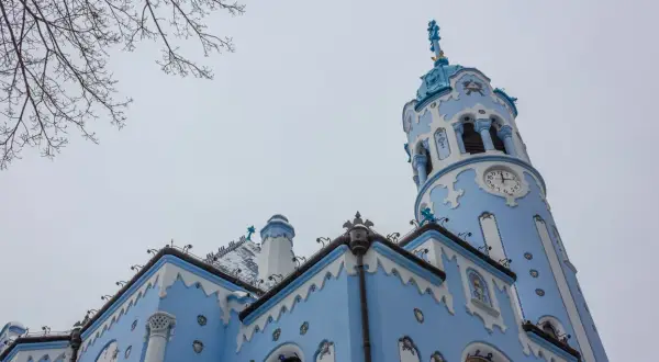 La Iglesia Azul de Bratislava en Navidad, con su torre de reloj y detalles blancos sobre fondo azul, parece sacada de un cuento.