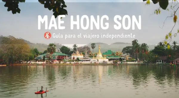 Paisaje sereno en Mae Hong Son con templos tailandeses y un pequeño bote en el lago.