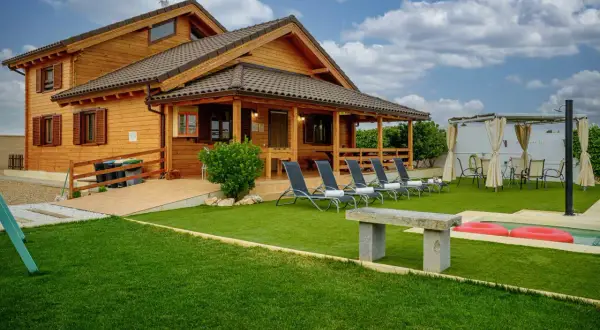 Casa de madera con piscina y tumbonas, ideal para explorar los pueblos cerca de Puy du Fou Toledo.