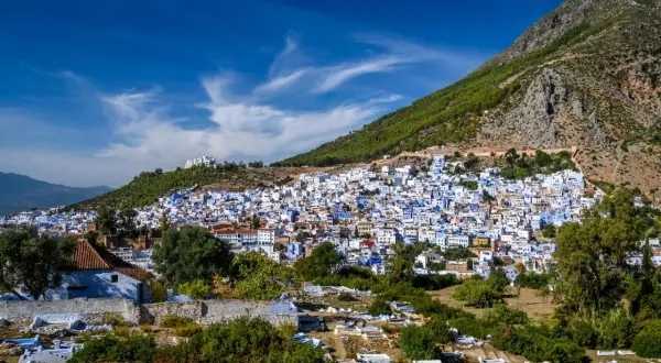 Vista panorámica de Chefchaouen, la ciudad azul, encaramada en una ladera montañosa. A pesar de su belleza, se rumorea que Chefchaouen es peligroso, con un cementerio en primer plano.