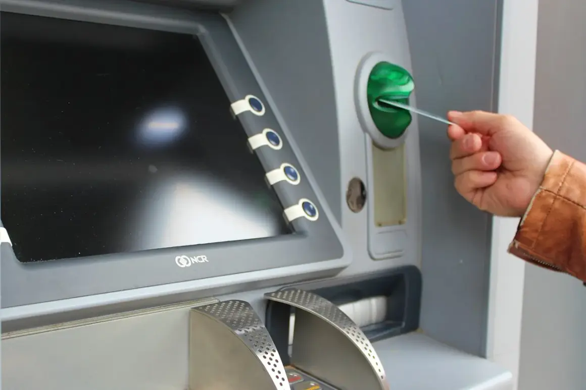 Mano insertando una tarjeta N26 extranjero en un cajero automático.
