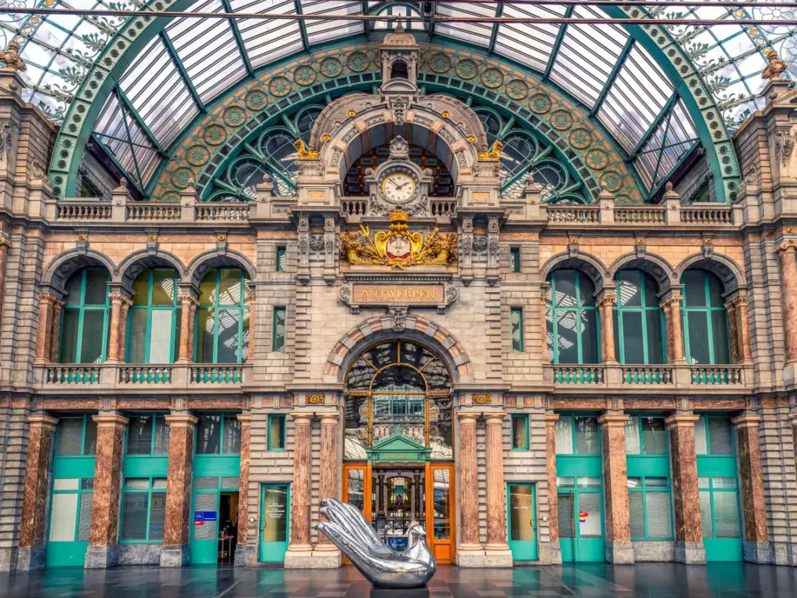 La estación de tren Bruselas Amberes, con su impresionante arquitectura y un ave plateada, te da la bienvenida.