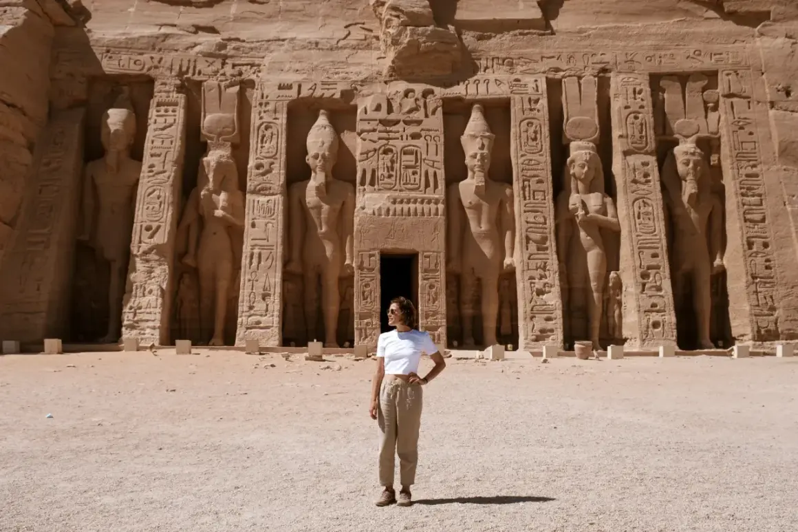 Mujer posa frente a colosales estatuas en Abu Simbel. ¡Excelentes consejos para viajar a Egipto!
