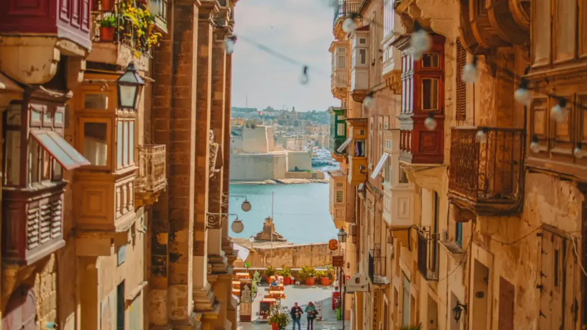 Calle estrecha con balcones de madera y vistas al mar. Ideal para escapadas fin de semana Europa.